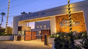 Une entrée moderne d’un immeuble, avec une enseigne indiquant « PLANTA DE MAR » et « Projet immobilier en bord de mer ».