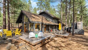 Een chalet met terras, buitenzitplaatsen en rieten dak.