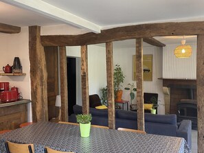A dining area with a table, chairs, and a potted plant. - LES POMMIERS - SINGLY (SINGLY)