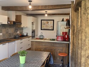 A kitchen with wooden beams, a tiled backsplash, a hanging light fixture, a framed recipe book, and a vintage toaster. - LES POMMIERS - SINGLY (SINGLY)