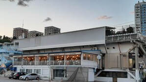 Edifici amb restaurant a la planta baixa, un balcó i una escala que condueix a un pis superior.