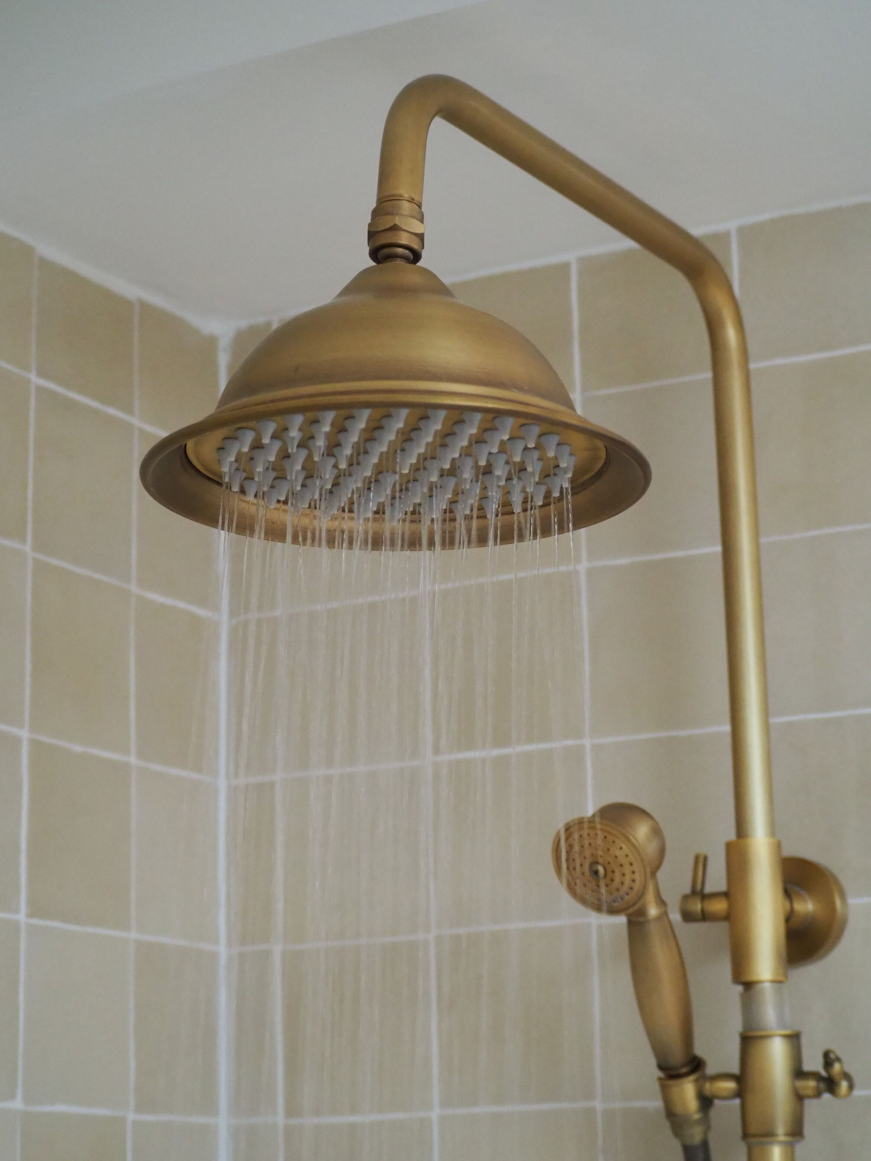 A showerhead with a curved arm and a rain-like water feature.