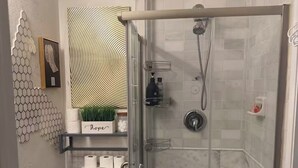 Ein Badezimmer mit Toilette, Dusche und Ablage für Toilettenartikel.