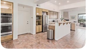 A modern kitchen with built-in appliances, a central island, and a dining area with a view. - Desert Escape in the Foothills!
Family friendly with pool and views (Tucson)