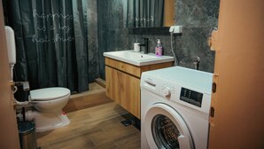 A bathroom with a toilet, washing machine, and sink. - Gorgeous 3-bedroom apartment with 5-Balconies in the Center of Skopje (Skopje)