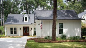 A two-story house with a front porch, a flag, and a well-maintained lawn. - Newly built 2bed/2bath house on Dataw Island; TWO WEEK MINIMUM (Saint Helena Island)