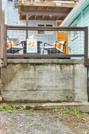 Ein begrenztes Areal mit einem Schild, das Parkplätze für Strandurlauber kennzeichnet, einer Betonmauer und einem Blick auf ein Gebäude mit Kachelfassade.