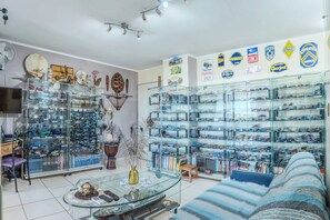 Une pièce avec des vitrines exposant divers objets, un canapé et un téléviseur.