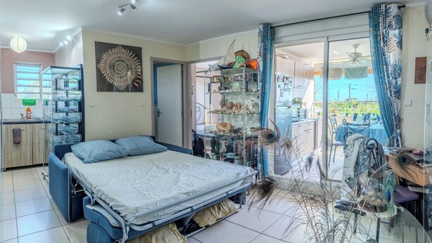 Ein Schlafzimmer mit Bett, einer Glastür zum Balkon und einer Regalanlage mit verschiedenen Gegenständen.