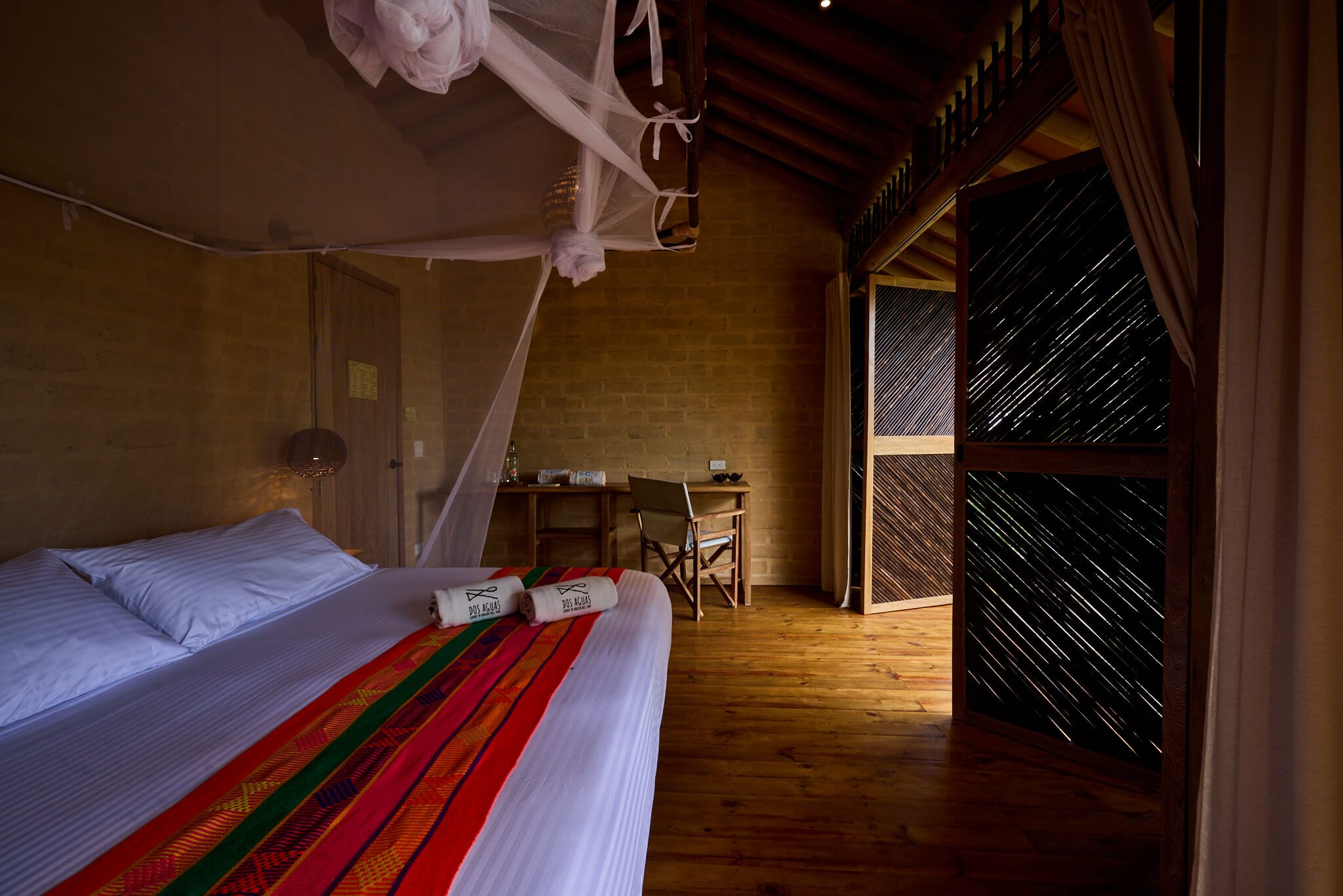 Quarto com cama, escrivaninha e janela com vista.