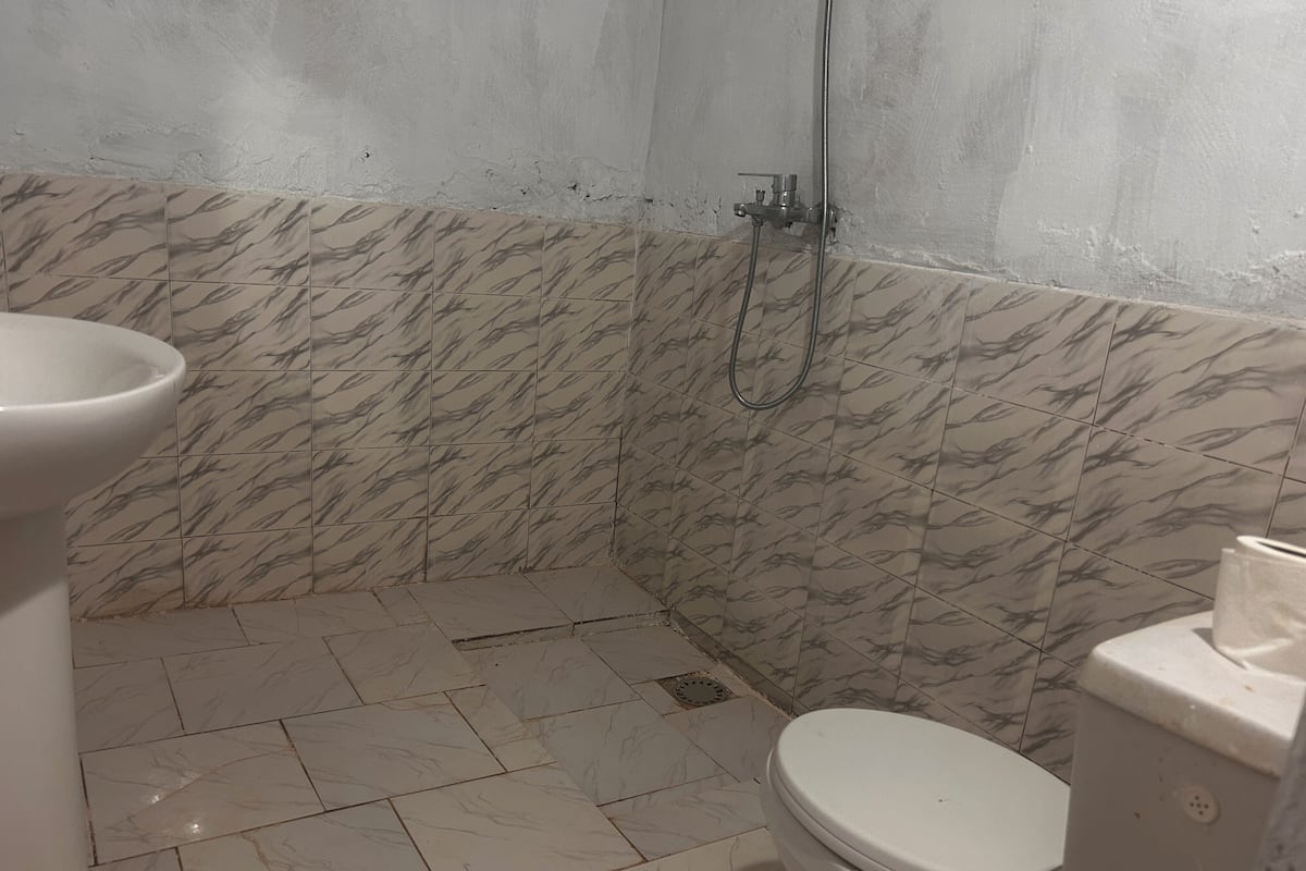 Een badkamer met een toilet, douche en wastafel.