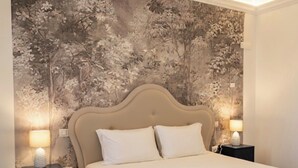 Une chambre à coucher avec un lit, deux tables de chevet et un papier peint à motifs floraux.