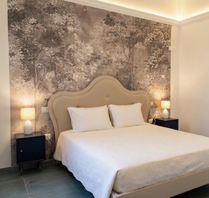 Ein Schlafzimmer mit einem Bett, zwei Nachttischen und blumigem Wandpapier.