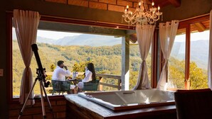 A room with a large window, a telescope, and a hot tub. - Chalet 2 - Mountain Range: Design with Hot Tub in the Canyons - Comfort 7km from the Center (Praia Grande)