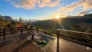 A wooden deck with a view of a valley and mountains, a hammock, and a person relaxing. - Chalet 2 - Mountain Range: Design with Hot Tub in the Canyons - Comfort 7km from the Center (Praia Grande)