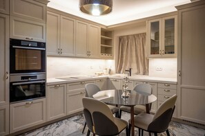 A modern kitchen with built-in appliances, a dining area with a round table and chairs, and light-colored cabinetry. - Private Villa - Poolside Retreat | Sea View & Calm Escape (Stelida)