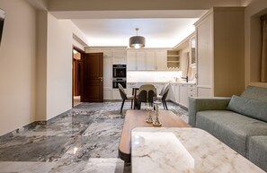 A modern kitchen with white cabinets, a dining area with a marble table, and a grey sofa. - Private Villa - Poolside Retreat | Sea View & Calm Escape (Stelida)