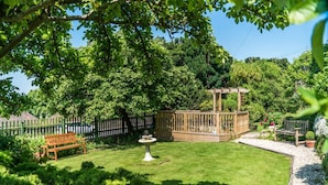 A well-maintained garden with a wooden pergola, a fountain, and a bench. - Superior Double Room in Bath (Bath)