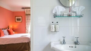A hotel room with a bed, a white sink, a mirror, and toiletries on a shelf. - Superior Double Room in Bath (Bath)