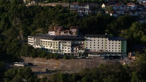 A hotel with multiple floors, a prominent sign, and a waterfront view.