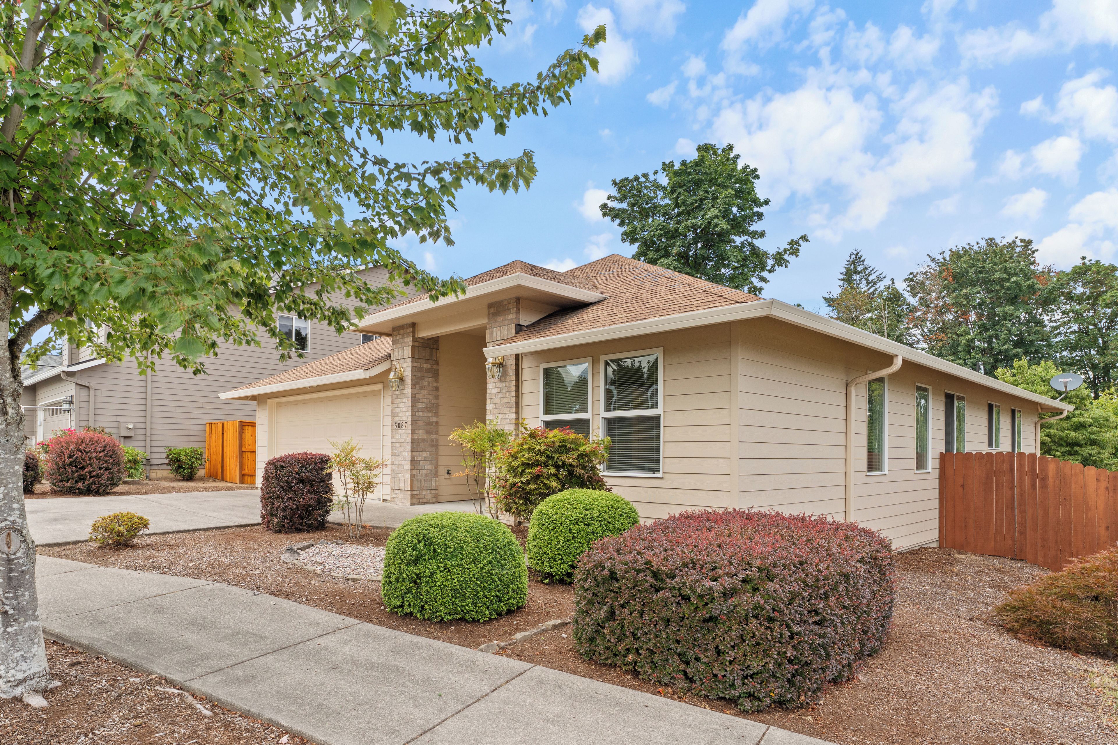 A single-story house with a front porch, a garage, and a well-maintained lawn.
