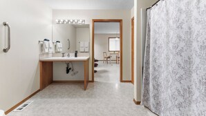 Une salle de bain avec un lavabo, un miroir et des luminaires au-dessus du meuble-lavabo.