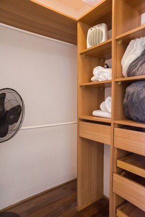 A wooden closet with shelves containing folded towels and a white heater. - Bright 1BR Las Condes  Apartment in Prime location (Las Condes)