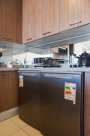 A kitchen with wooden cabinets, a stainless steel refrigerator, and a granite countertop. - Bright 1BR Las Condes  Apartment in Prime location (Las Condes)