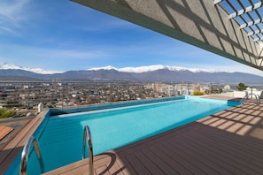 Ein Pool mit Blick auf eine Stadt und Berge im Hintergrund.