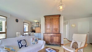 A living room with a sofa, a coffee table, a wooden cabinet, and a chair. - Portulans d'Orient - PORT LOUIS (PORT LOUIS)