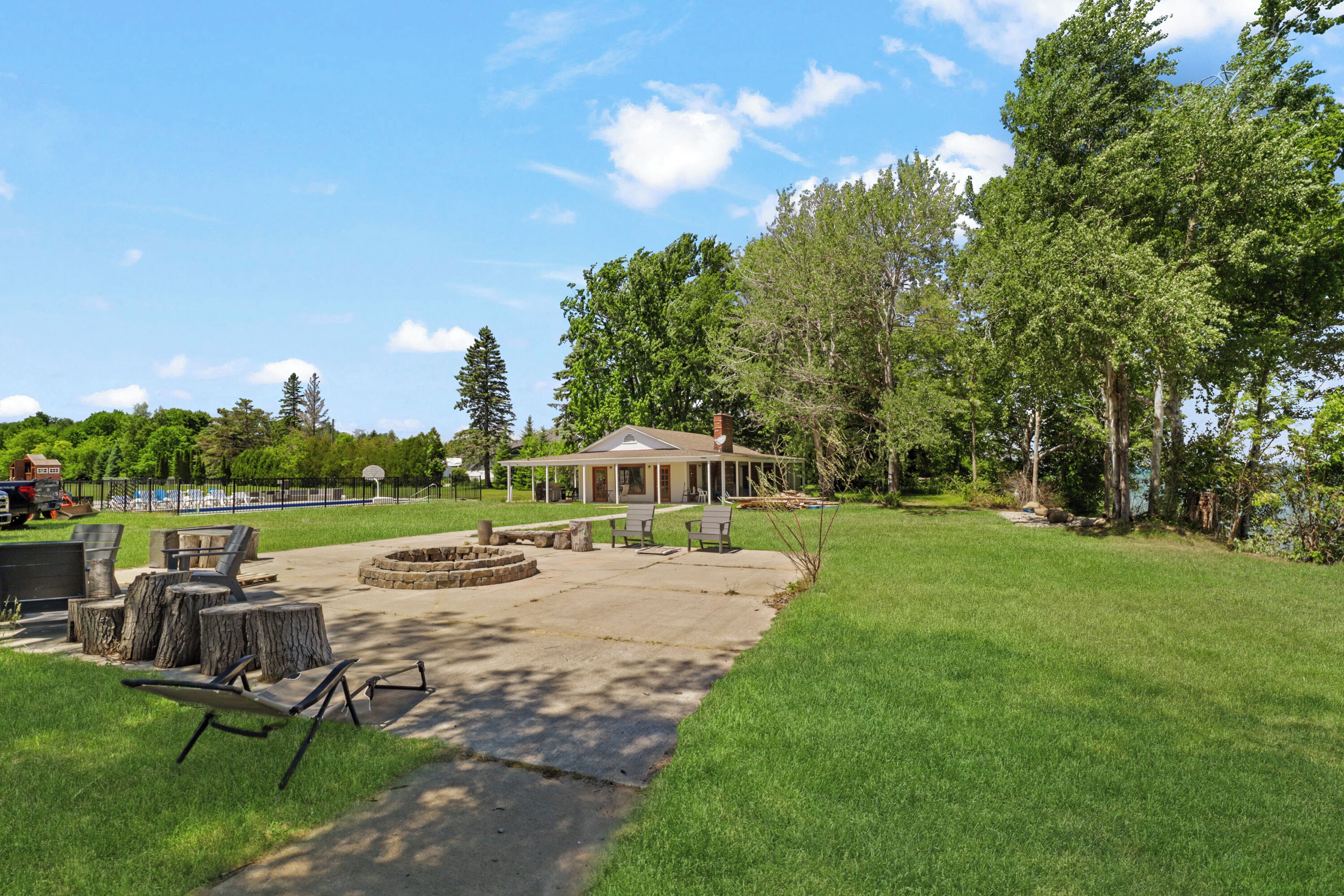A gazebo with a fire pit, outdoor seating, and a view of a lake.