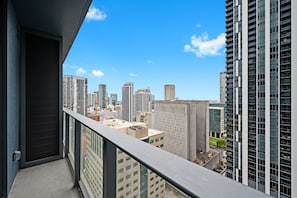 Ein Hochhaus mit einem Balkon, der auf eine Stadtlandschaft blickt.