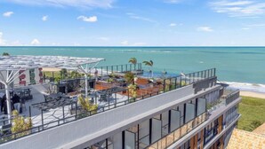 Eine Dachterrasse mit Meerblick, Sitzgelegenheiten im Freien und einem Poolbereich.