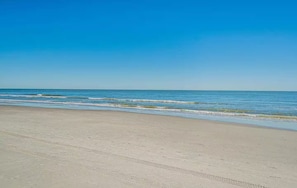 Ein Strand mit klarem Himmel und ruhiger See.