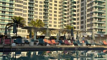Un hotel de gran altura con piscina, varios balcones y zonas de estar al aire libre.