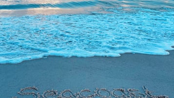 Una playa con la frase 'Seascape Suites' escrita en la arena.