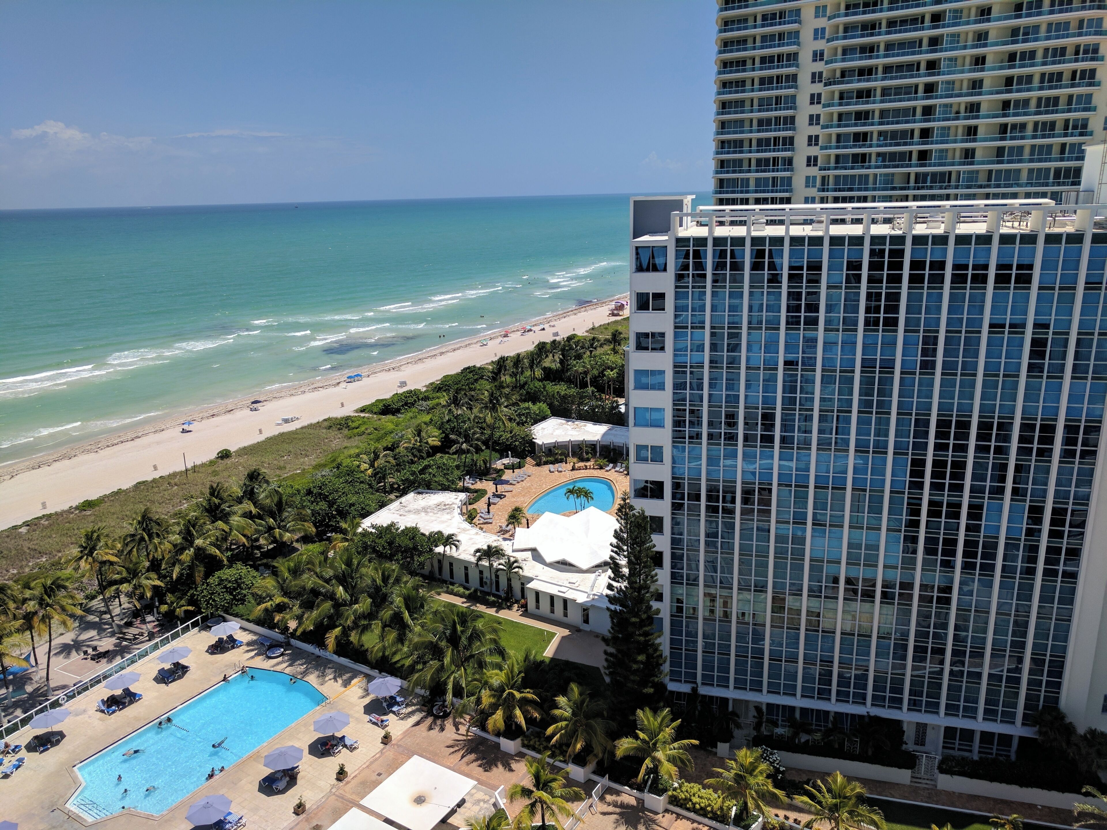 Un hotel moderno con piscina en la azotea y vistas a la playa.