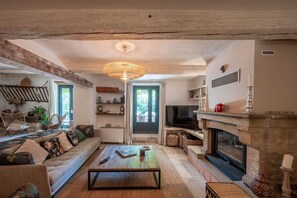 Ein gemütliches Wohnzimmer mit einer Couch, einem Couchtisch, einem Kamin und einem Fernseher.