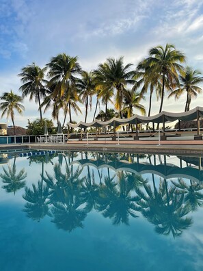 A swimming pool with palm trees and a covered seating area. - 2 X 2 Bedroom Suites Partial OceanView, beachaccess adjacent rooms C D E F units (Miami Beach)
