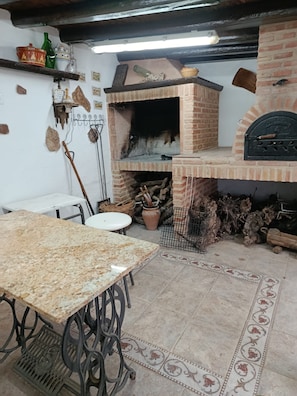 Eine rustikale Küche mit Backofen, einem Holztisch und einem Musterfußboden.