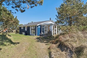 A small, single-story house with a porch and a covered outdoor seating area. - Holiday home in Vorupør near sea and nature (Thisted)
