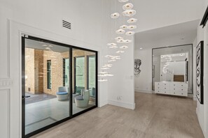 Ein modernes Interieur mit Glastür zu einem Außenbereich, einer Treppe und einem minimalistischen Design.