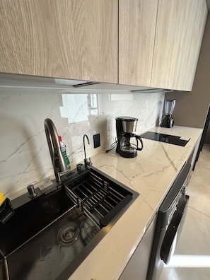 A modern kitchen with a sink, faucet, coffee maker, and a stove. - Quito luxury suite (Quito)