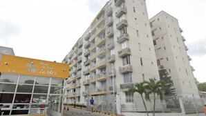A multi-story residential building with balconies, a glass entrance, and a yellow sign with text. - Comfortable apartment in Barranquilla, warmth of home, with pool, parking, gym and wifi. (Barranquilla)