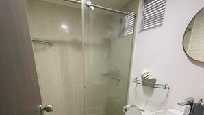 A bathroom with a glass-enclosed shower, a toilet, and a sink. - Comfortable apartment in Barranquilla, warmth of home, with pool, parking, gym and wifi. (Barranquilla)