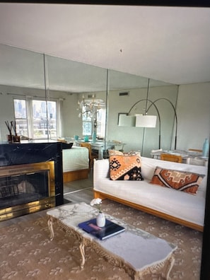 A modern living room with a sofa, a coffee table, a fireplace, and a large mirror. - Exclusive 6Bed5Bath Penthouse • NYC view • Parking (Weehawken Township)