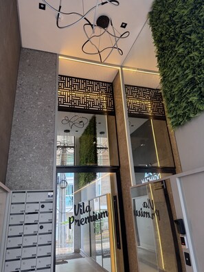 A modern hotel entrance with a glass door, a keypad, and a sign reading 'Vila Premium.' - Apartment Flor de Romã - Villa Premium - 150m from the Thermal Park, Family-Friendly, Relaxing, Cozy (Piratuba)