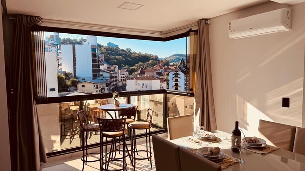 Ein Balkon mit Esstisch, Stuhl und einer Weinflasche.