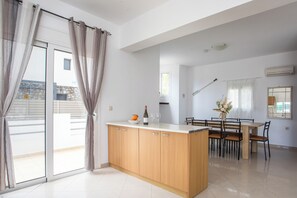 Una cucina moderna con isola centrale, tavolo da pranzo e sedie.