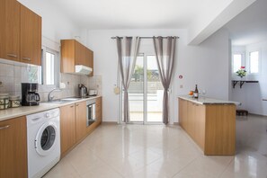 Una cucina moderna con lavatrice, macchina del caffè e lavello.
